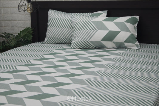 A bed with a geometric patterned aqua bed sheet set.