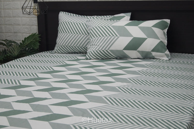 A bed with a geometric patterned aqua bed sheet set.