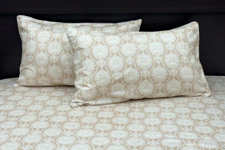 A beige custom bed sheet set with floral print and piping pattern displayed on a bed, including two pillows 1.
