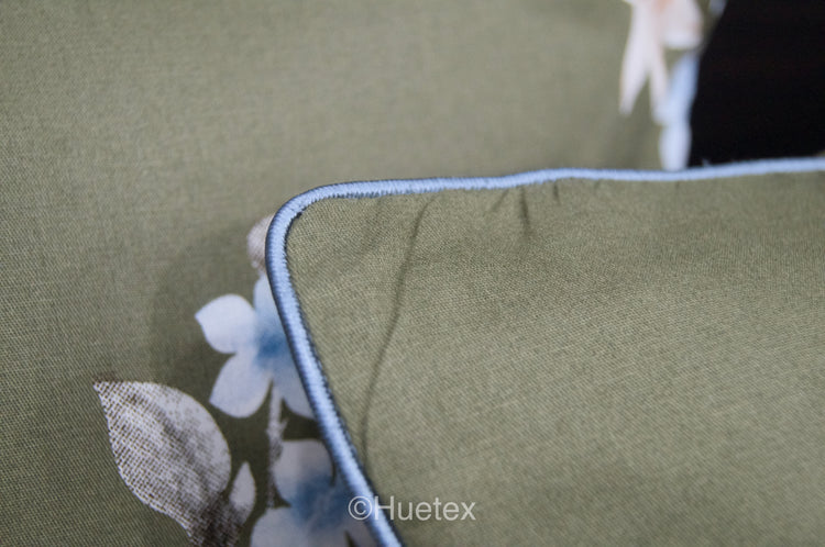 A custom bed sheet and pillow with floral geometric print in green