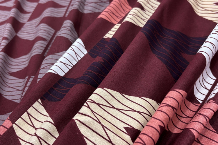 A custom bed sheet in brown with geometric print.