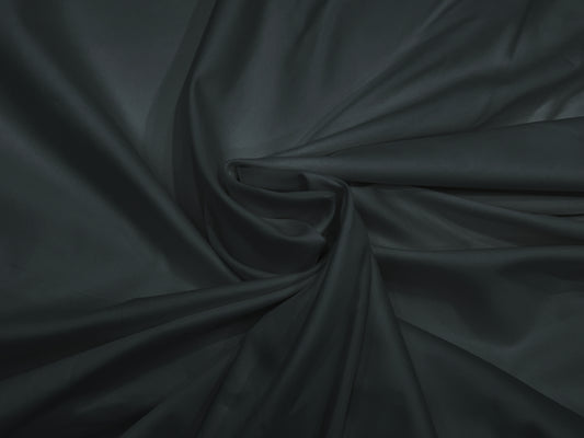 A dark grey, sateen weave bed sheet set displayed in a twisted .