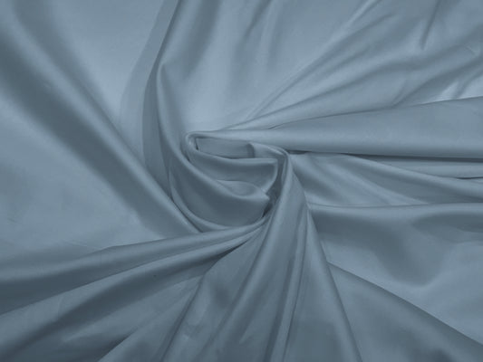 A draped bed sheet with a soft blue color and a sateen weave texture.