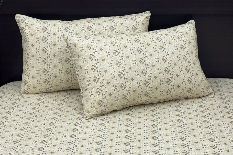 A neatly made bed with a beige floral-patterned sheet and two matching pillows 1 .