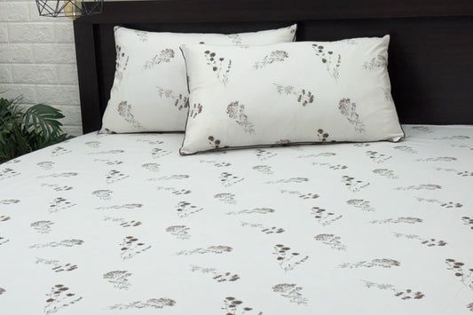 A neatly made bed with a white sheet and two pillows.