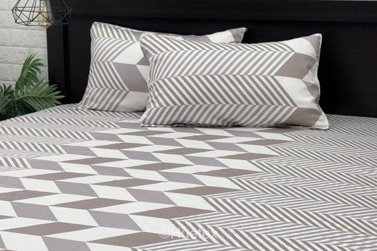 A set of pastel-colored bed sheets with pillow in a geometric print .