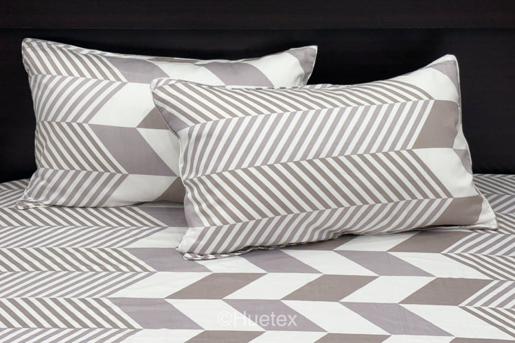 A set of pastel-colored bed sheets with pillow in a geometric print 1.