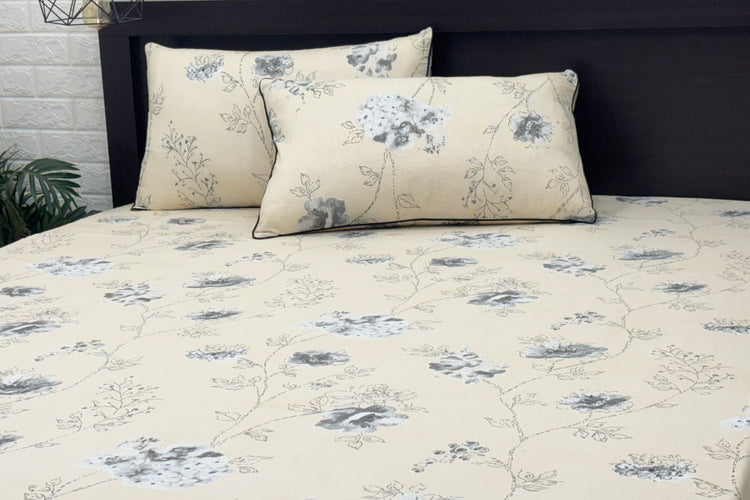 Beige bedspread with a delicate gray floral pattern, featuring matching pillows 1.