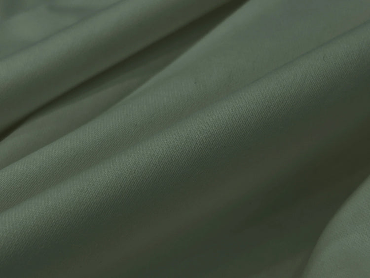 Close-up of soft, light gray fabric with gentle fold bedsheet
