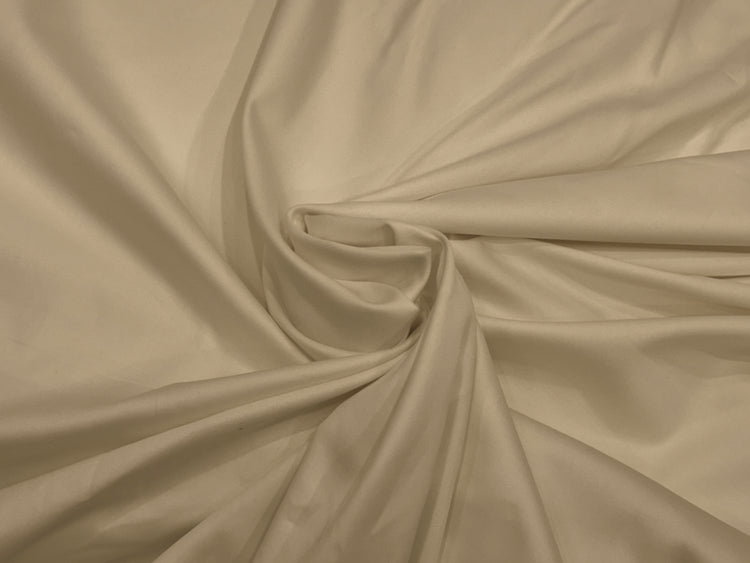 Cream-colored fabric bedsheet swirled in a circular pattern.