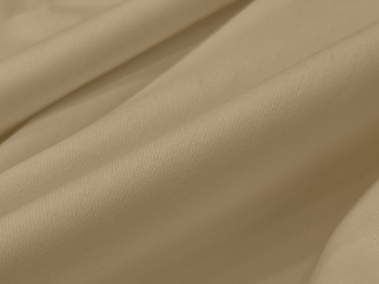 Smooth beige fabric with gentle folds, creating a soft and elegant texture.