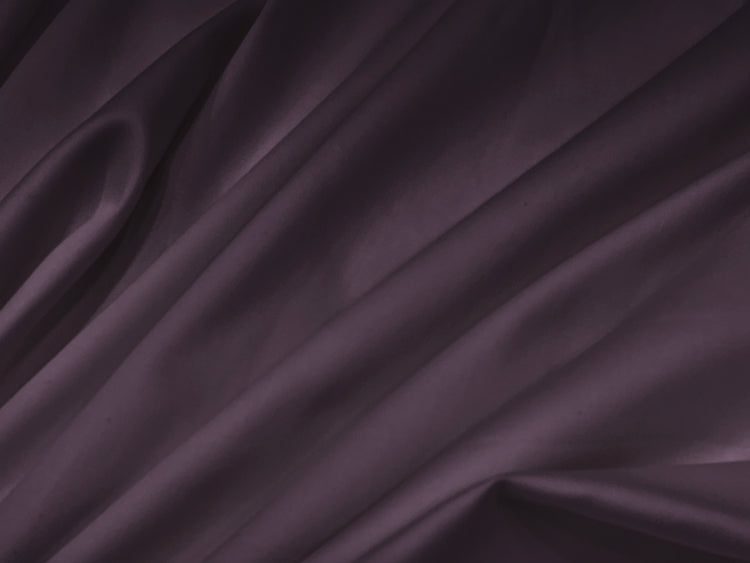 Smooth, folded dark purple fabric with soft shadows creates a rich, elegant texture.
