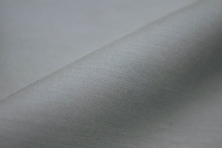 Smooth gray fabric with a soft texture, angled and slightly folded.