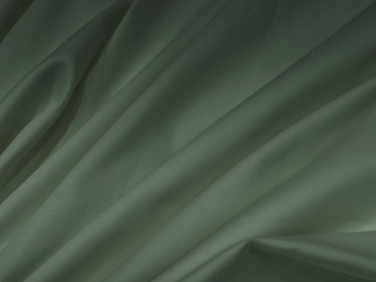 Smooth, light gray satin fabric with gentle folds and shadows, creating a soft, elegant texture.