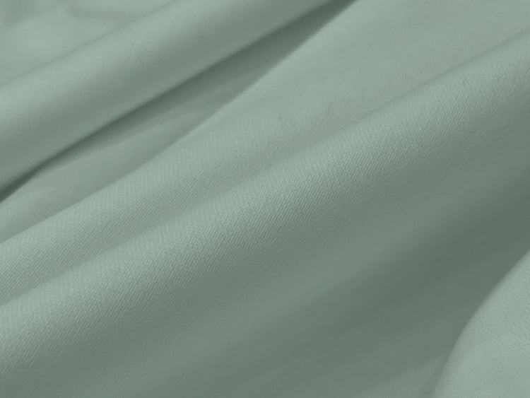 Smooth, soft folds of light gray fabric bedsheet