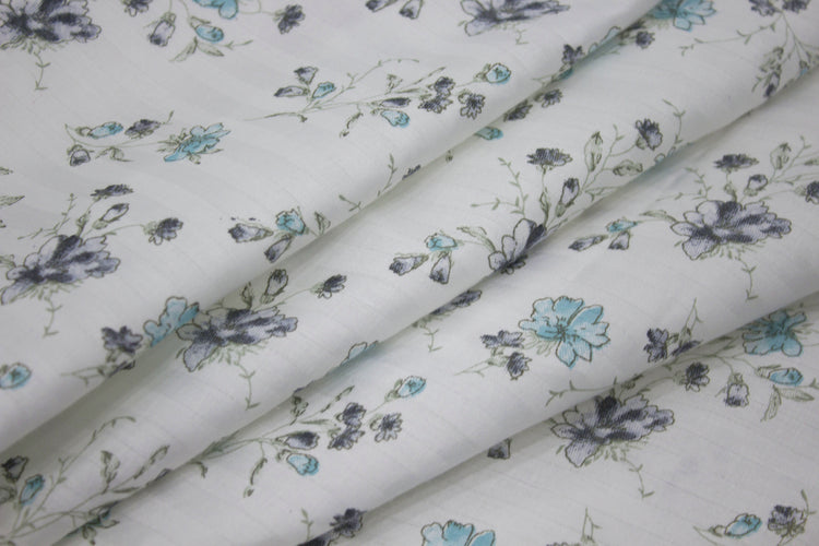 bedsheet with a floral print design, shades of blue and green neatly folded .