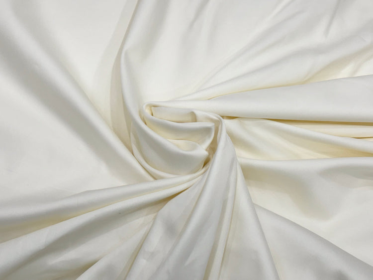 Smooth white silk fabric gracefully draped, forming a gentle spiral at the center.