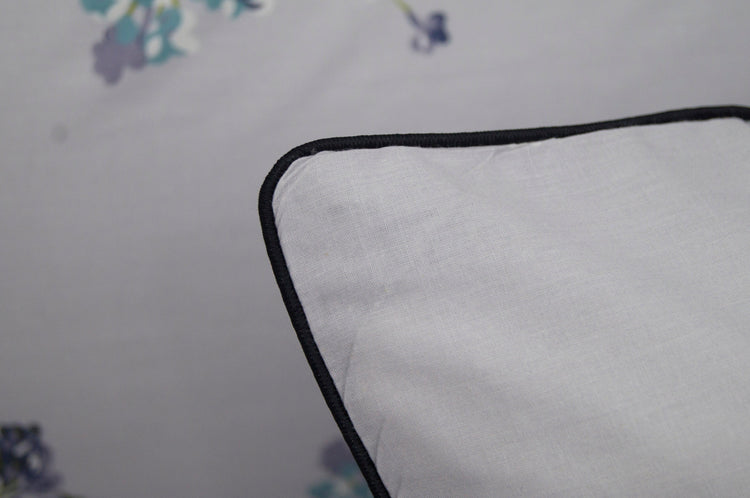 A pillow with a floral print design bedsheet in shades of purple