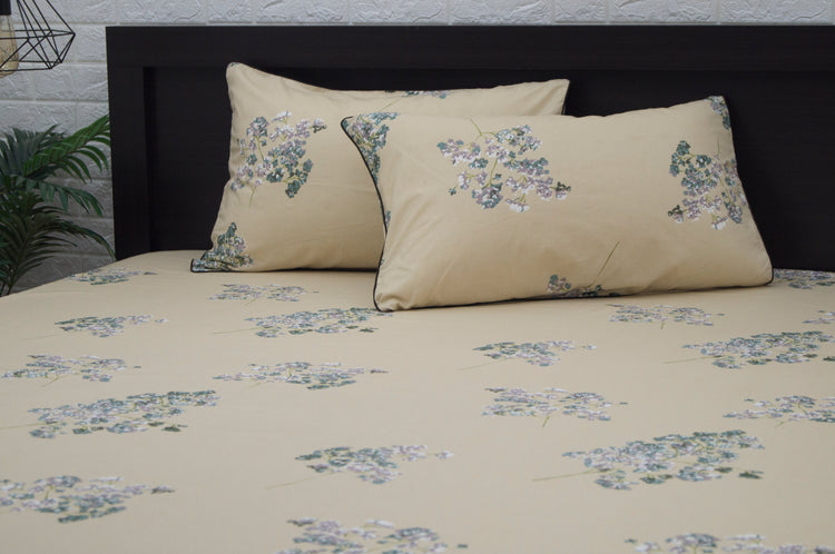 Two beige pillows with floral patterns, featuring small purple and green flowers 1.
