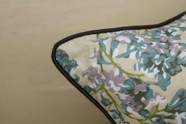 pillow with floral patterns, featuring small purple and green flowers.