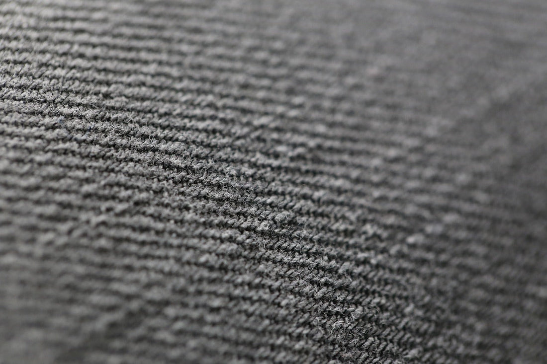 Close-up of a gray, ribbed fabric texture, showcasing fine parallel lines.