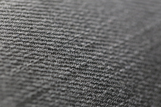 Close-up of a gray, ribbed fabric texture, showcasing fine parallel lines.