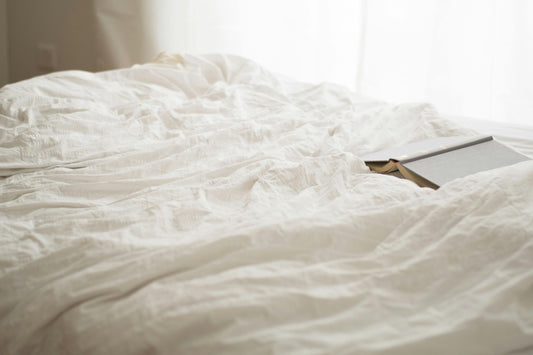 A cozy, wrinkled white soft bed sheet