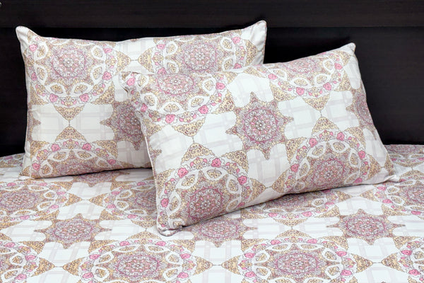 A bed dressed with a white and pink geometric-patterned bedsheet and matching pillows 1.