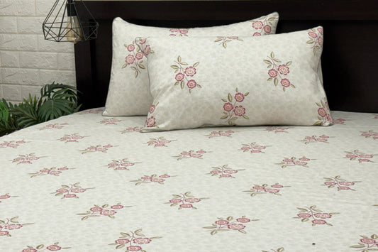 A bed sheet and pillowcases with a floral print design in shades of grey and pink .