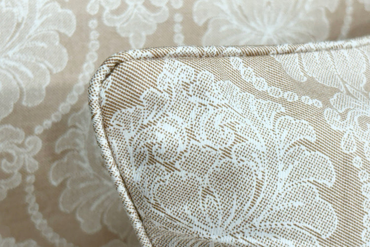 A beige custom bed sheet  with pillow floral print and piping pattern