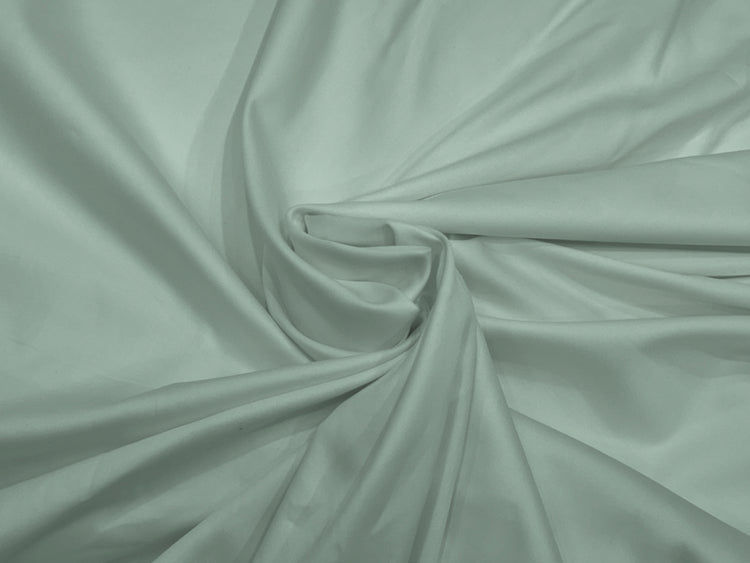 A draped bed sheet with a soft green color, showcasing the sateen weave texture.
