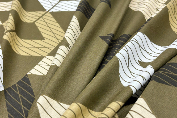 A green bed sheet with a geometric pattern.