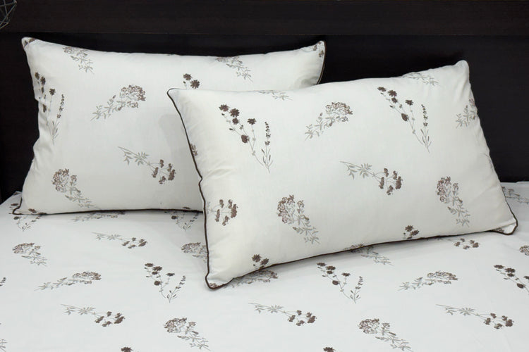 A neatly made bed features a white sheet and two matching pillows 1