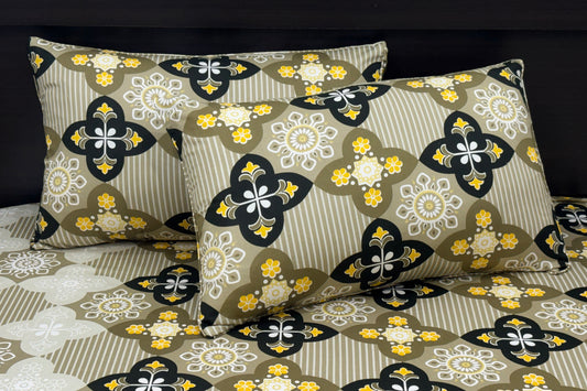 A set of bed sheets and pillows with a green floral print pattern.