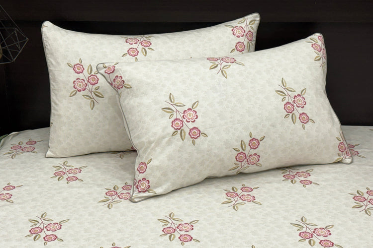 A set of white bed sheets with a floral print pattern in shades of grey.