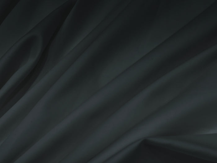 Bedsheet Smooth, flowing black silk fabric with soft folds .