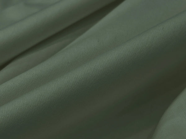 Close-up of soft, light gray fabric with gentle fold bedsheet 