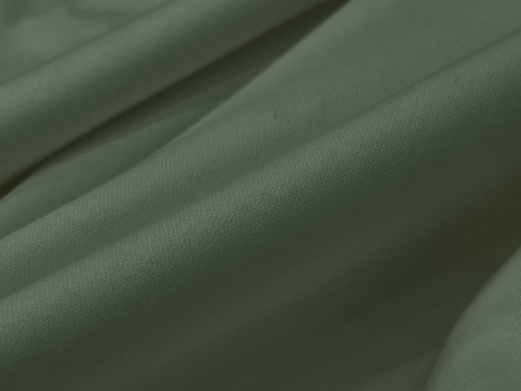 Close-up of soft, light gray fabric with gentle fold bedsheet 