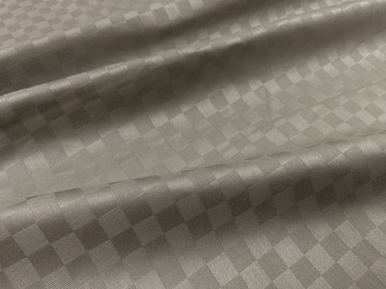 Close-up view of a beige checkered pattern bed sheet fabric 2.