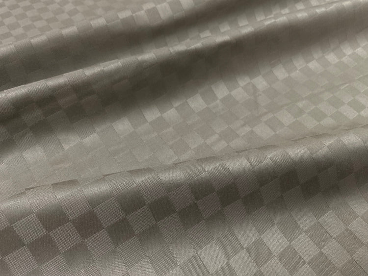 Close-up view of a beige checkered pattern bed sheet fabric 2.