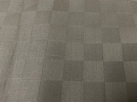 Close-up view of a beige checkered pattern bed sheet fabric 3.