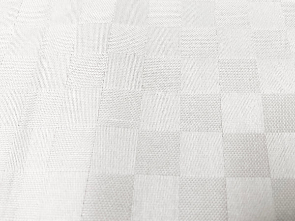 Close-up view of a white custom bed sheet with a sateen self square weave pattern 3.