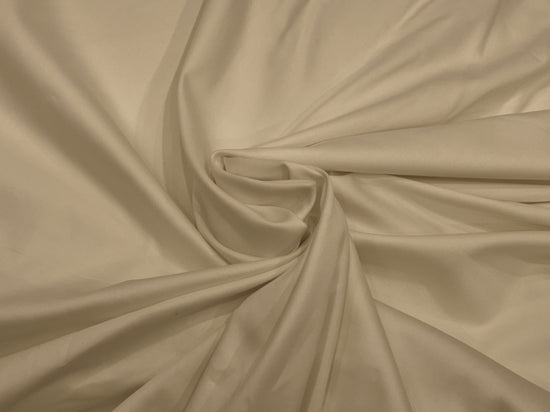 Cream-colored fabric bedsheet swirled in a circular pattern. 