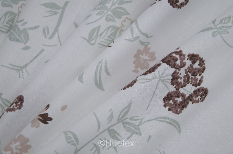 Custom bed sheet  with floral print with brown, white, and green colors and folding softly.