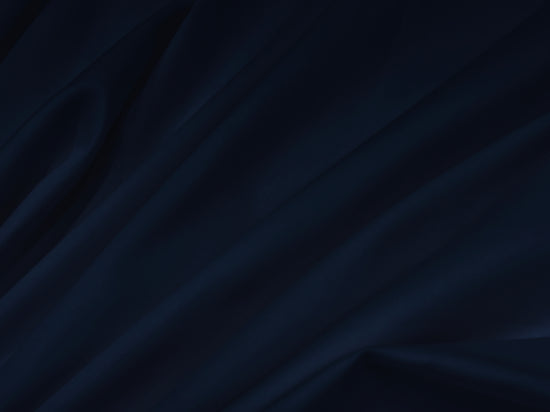 Dark blue fabric with soft, flowing folds bedsheet. 