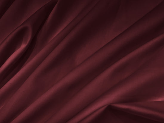 Luxurious burgundy silk fabric with soft, flowing folds