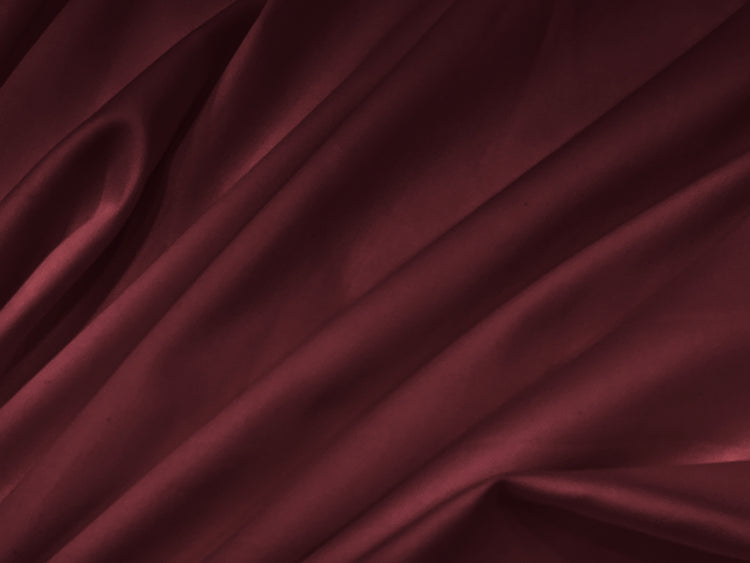 Luxurious burgundy silk fabric with soft, flowing folds
