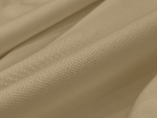 Smooth beige fabric with gentle folds, creating a soft and elegant texture.