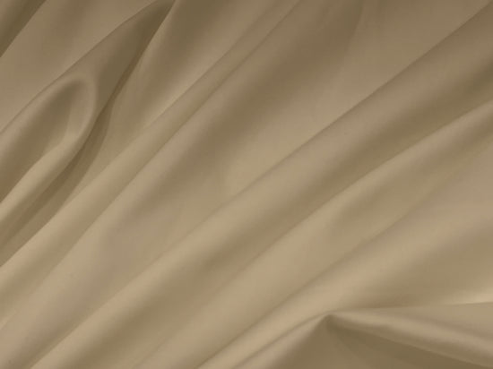 Smooth, beige satin fabric with soft folds and gentle draping. 