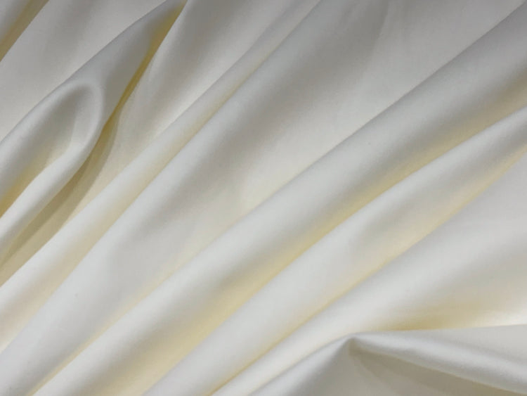 Smooth, flowing ivory satin fabric with gentle folds.